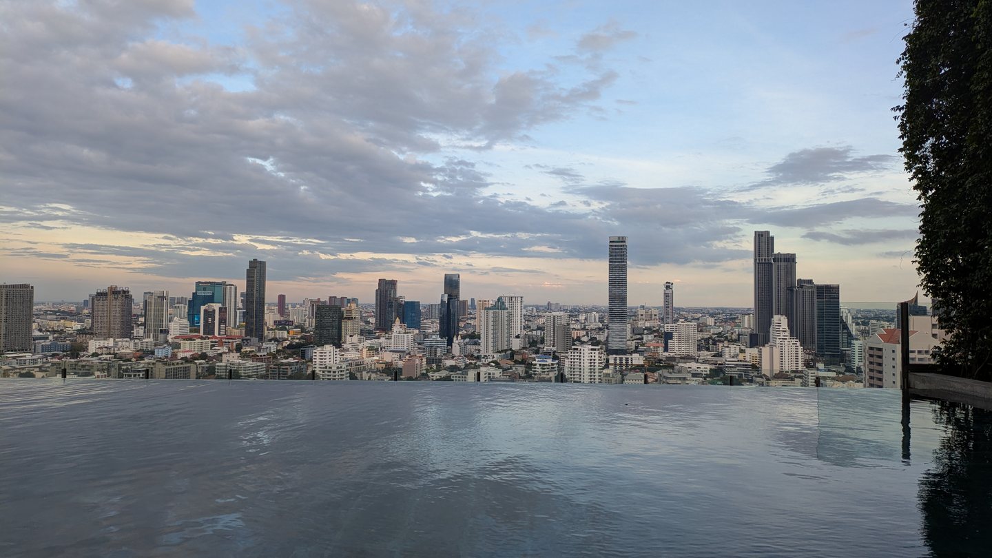 The Bangkok skyline at dusk seen from a rooftop infinity pool
