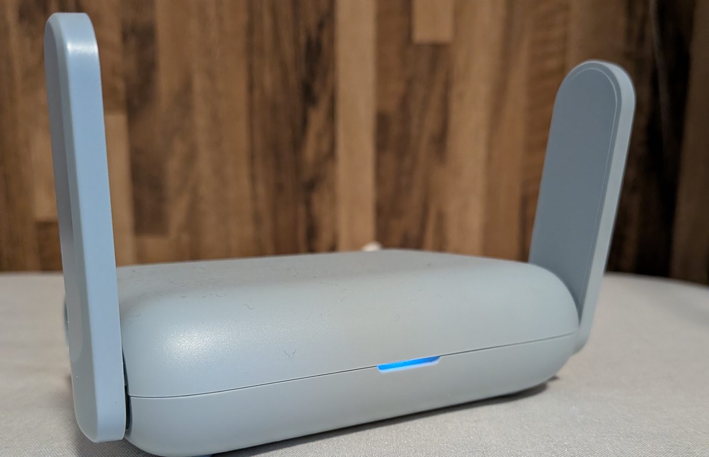 The GL.iNet Beryl AX (GL-MT3000) travel router with its two antennas raised and the blue status light on