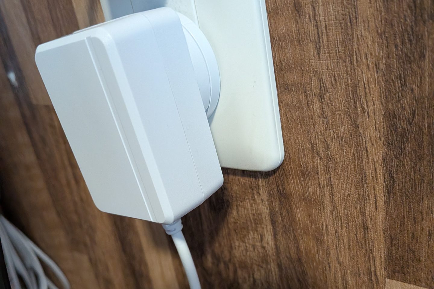 The Beryl AX power adapter plugged directly into a wall outlet