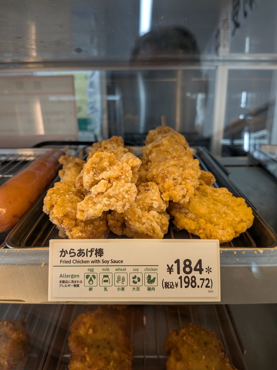 Fried chicken at a supermarket deli counter with the price shown on the sign