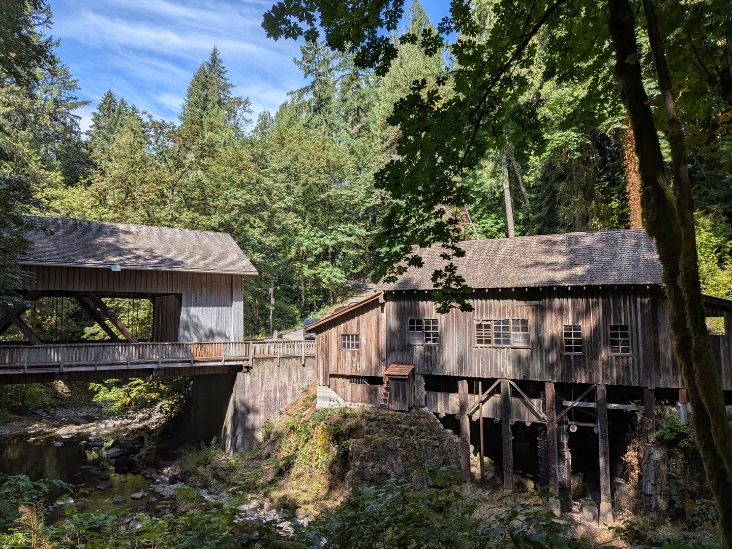 The weathered wooden Cedar Creek Grist Mill beside a creek and surrounded by trees