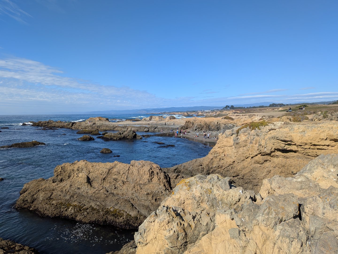 Rocky shoreline and sunlit water along the Northern California coast