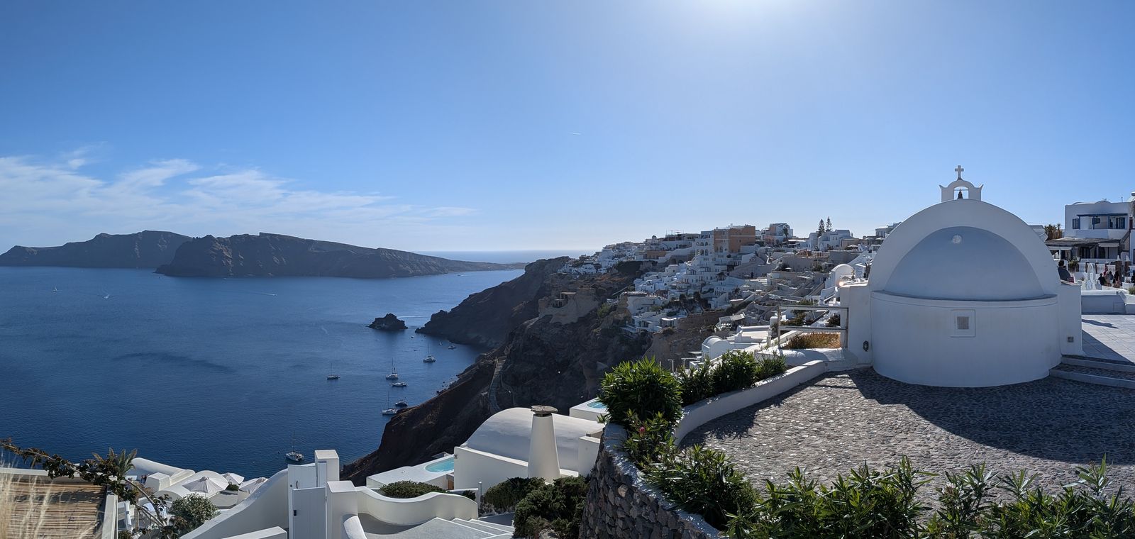 White-domed church and cliffside houses in Oia, Santorini, above the deep blue Aegean